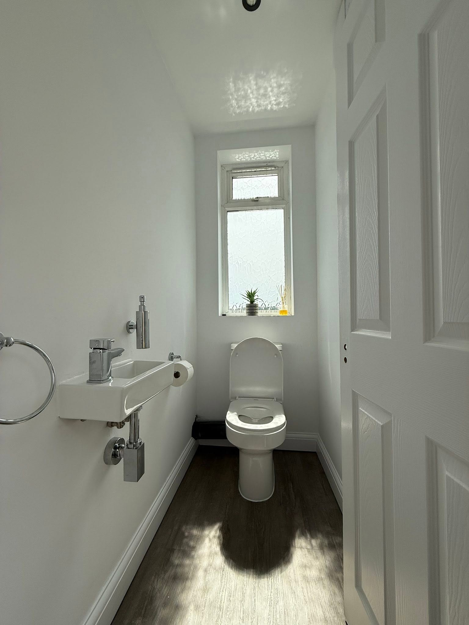 Completed white cloakroom with wall-mounted basin