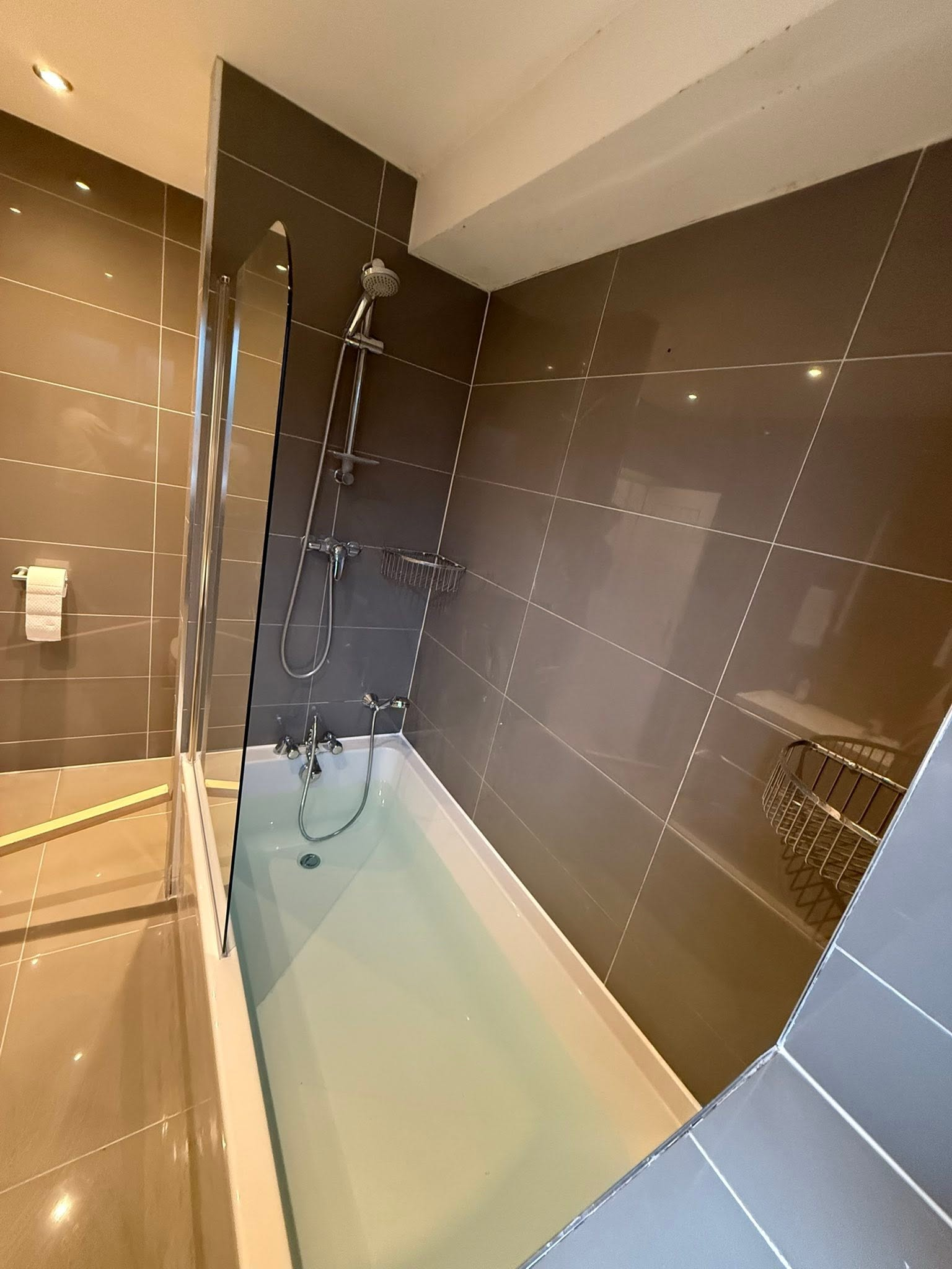 Bath and shower installation with grey wall tiles