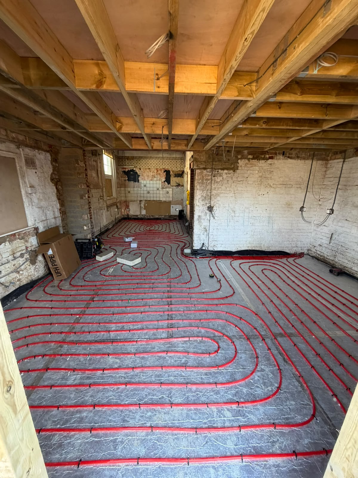 Underfloor heating pipework installed across a renovation